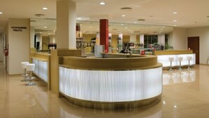 A modern hotel lobby with a reception desk, bar area, and seating. - Città Della Notte (Melilli)