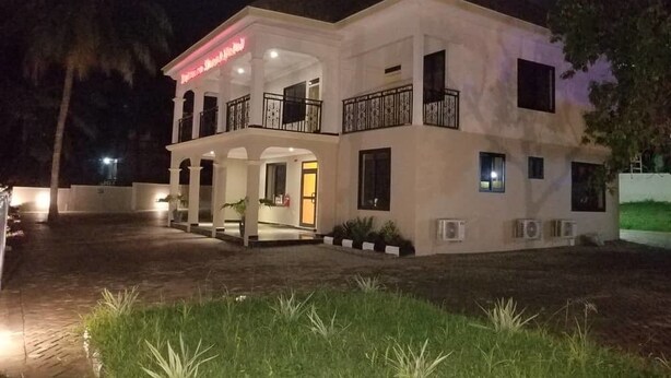 A two-story building with a balcony and a covered entrance. - Balance Sheet Hotel (Cape Coast)