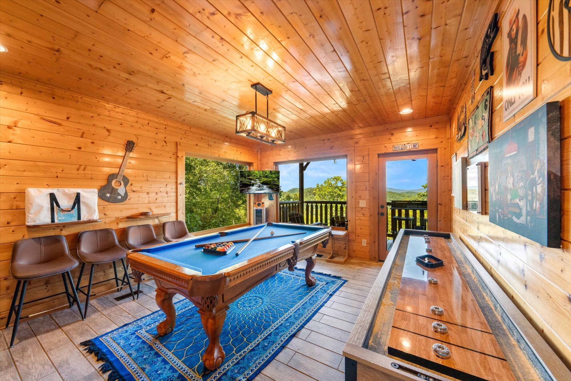 Uma cabana de madeira com mesa de bilhar, cadeiras e mesa de rebatedores.