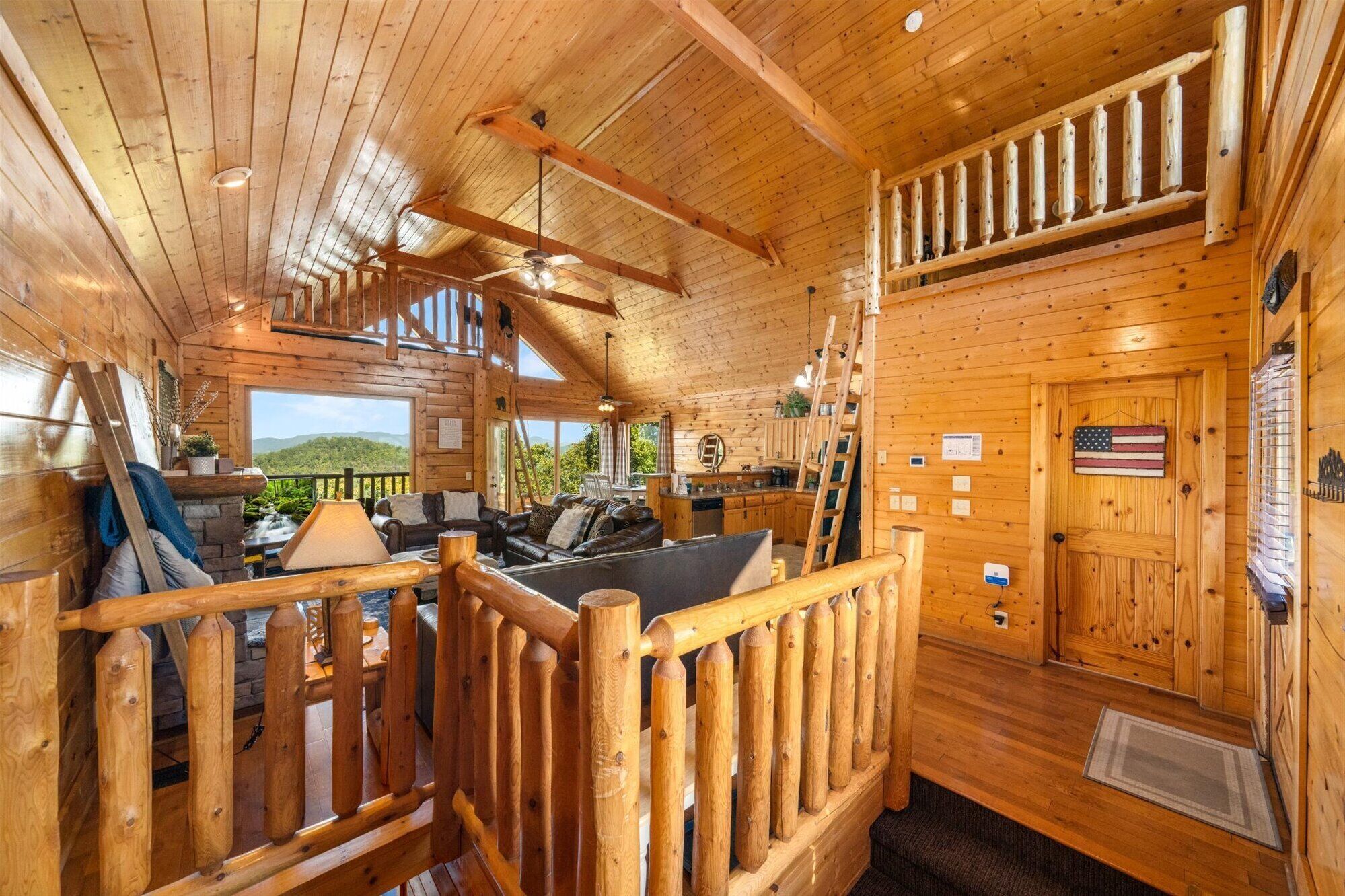 A cabin interior with a wooden interior, a dining area, and a view of the outdoors.