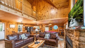 A spacious lodge with wooden interiors, a billiards table, and a stone fireplace. - Raccoons' Rest: Kick Back in the Smokies (Pigeon Forge)