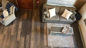 Un salón con un sofá gris, una mesita de centro con diseño geométrico y una alfombra estampada.