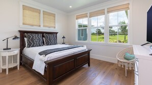A bedroom with a large bed, a desk, and a chair.