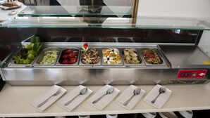 Un buffet con diverse portate e posate.