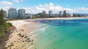 A coastal cityscape with a sandy beach and clear turquoise waters. - Ocean Plaza 1466 - Coolangatta Beachfront - Min. 3 Night Stays! (Coolangatta)