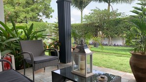 An outdoor patio with wicker furniture, a glass table, and a lantern. - Luxuriously furnished modern home with open-plan design. Tema Spintex (Tema)