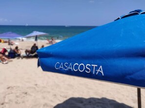 Ein Strandsonnenschirm mit der Aufschrift 'CASACOSTA'.