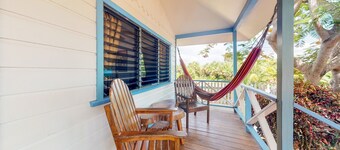 Cabana with a porch, hammock, & view of the pool & grilling area