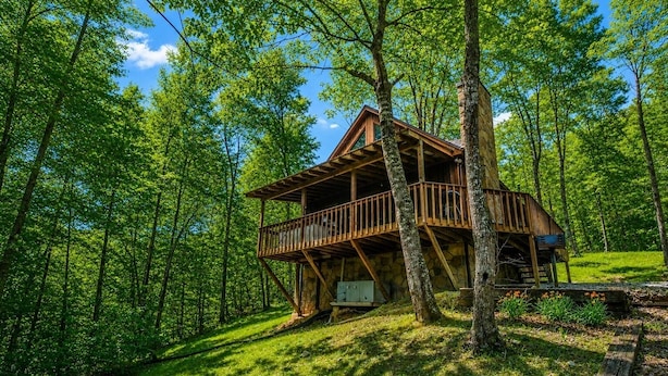 Eine Holzhütte mit Balkon, umgeben von einem Wald.