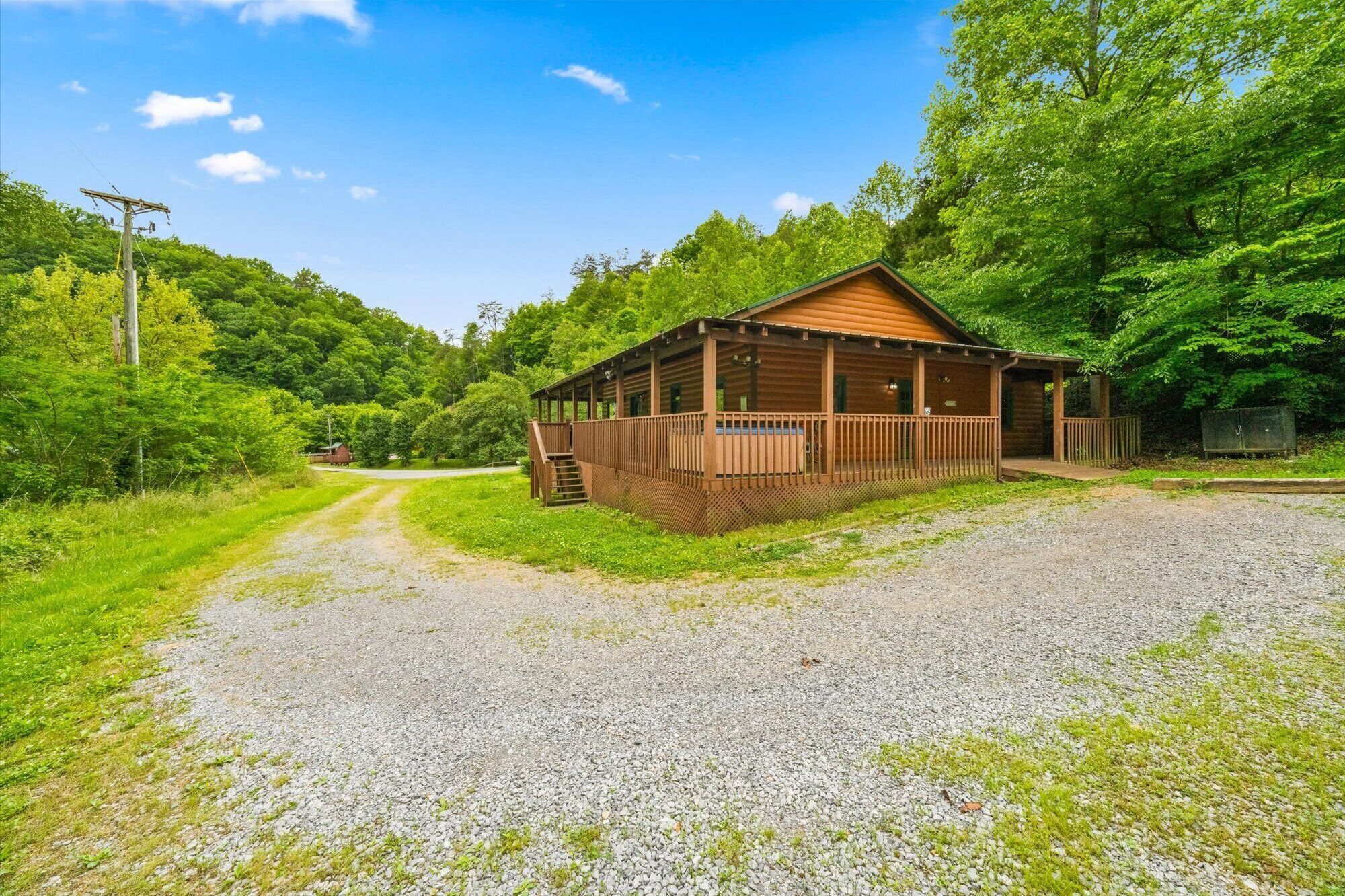 Un chalet rustique doté d’une terrasse en bois et d’une allée gravillonnée.