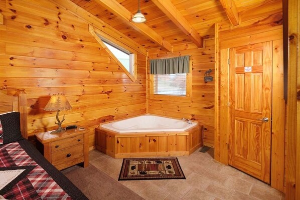 A wooden cabin with a large wooden bathtub, a small window with a curtain, and a door with a sign. - Cabin Fever: The Only Cure Is Checking In (Pigeon Forge)