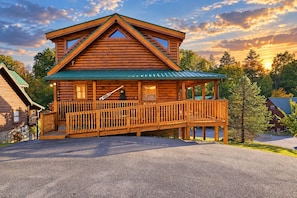 A log cabin with a balcony and a porch.