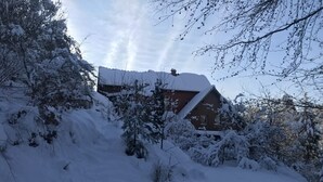 A snow-covered landscape with a house partially obscured by trees. - Gîte du ROCHER, 3 * in Alsace center (Lapoutroie)