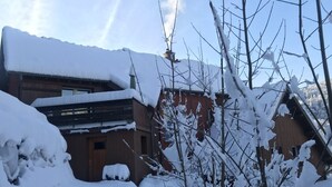 A snow-covered building with a sloped roof and a visible chimney. - Gîte du ROCHER, 3 * in Alsace center (Lapoutroie)