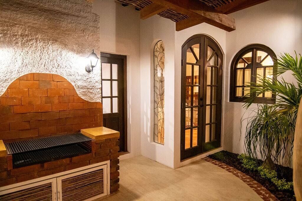 En ombonad inredning med en tegelkamin, välvda dörrar och en vägg av natursten.
