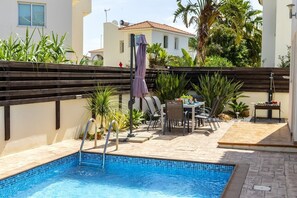Piscine extérieure en saison, chaises longues