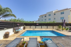 Piscine extérieure en saison, chaises longues
