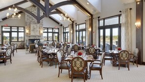 A spacious dining area with high ceilings, large windows, and modern chandeliers.