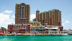 A multi-story hotel with balconies, a flag, and a waterfront view. - STEPS TO CRYSTAL BEACH see picture for location (Destin)