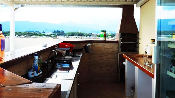 Eine Küche mit Bergblick, einem Grill und einem Kühlschrank.