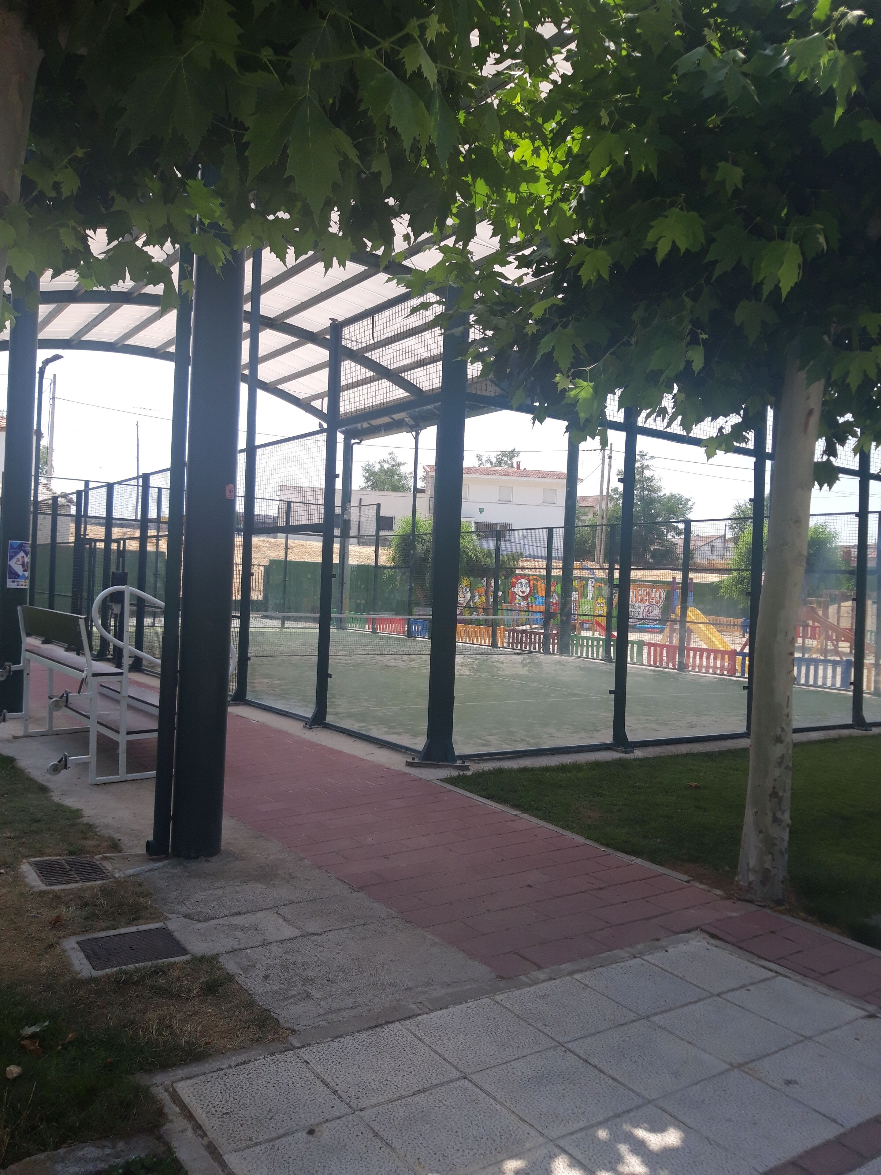 A covered outdoor area with a playground visible through the glass walls.