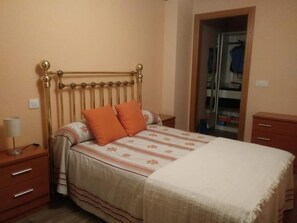 Une chambre à coucher avec un lit, une table de chevet, une lampe et une armoire.