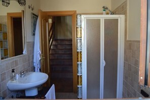 Une salle de bain avec un lavabo, un miroir et une douche.