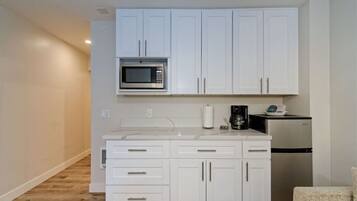 Fridge, microwave, coffee/tea maker, cookware/dishes/utensils