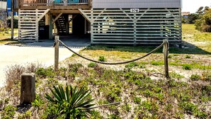 Een gebouw met twee verdiepingen, een houten terras en een bord waarop staat 'Coast Guard Station'.