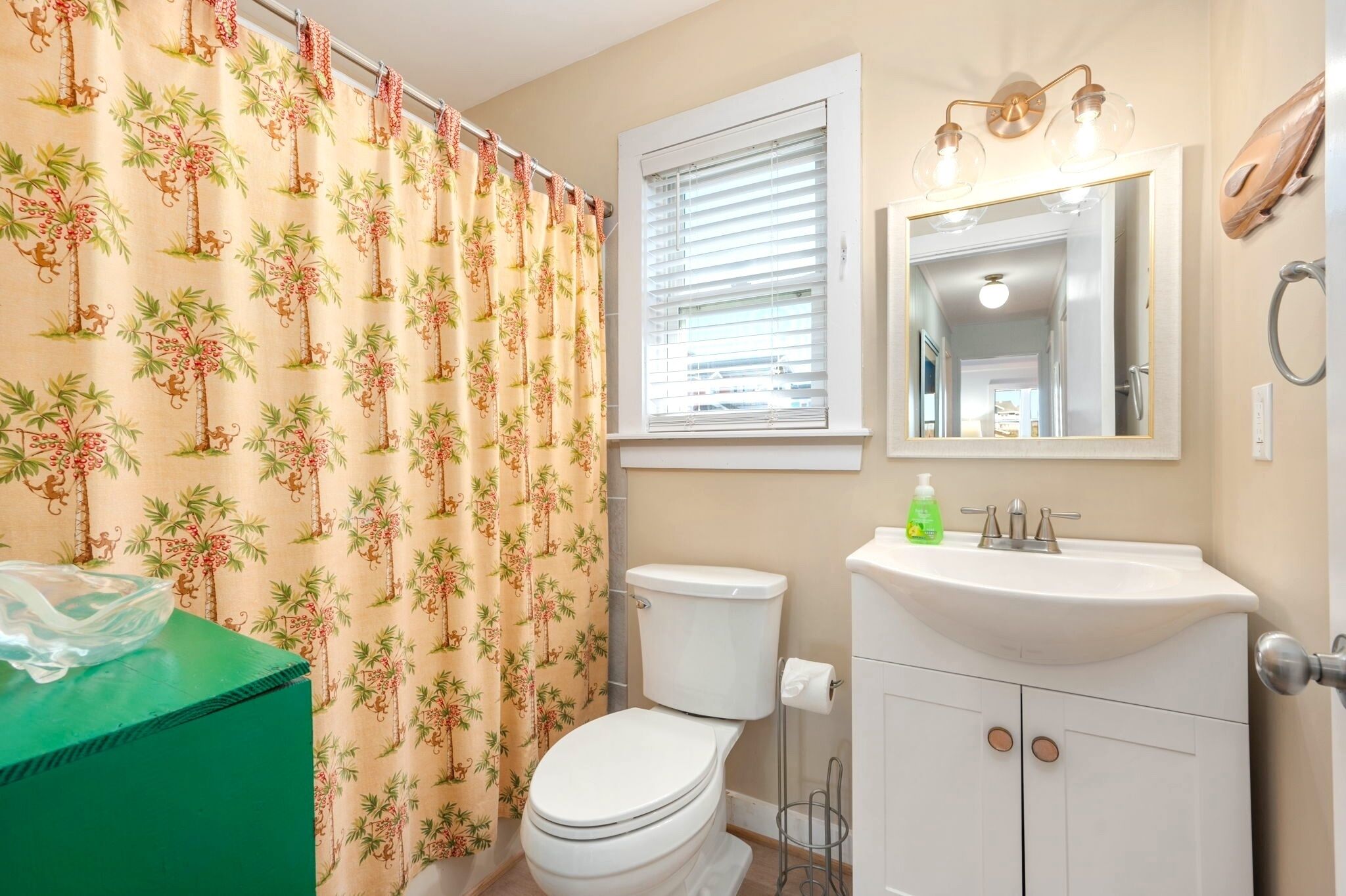 A bathroom with a toilet, sink, and shower curtain.
