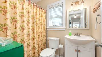 A bathroom with a toilet, sink, and shower curtain.