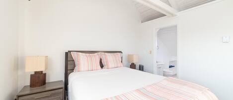 A bedroom with a bed, two bedside tables, and a nightstand.
