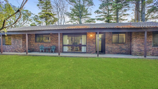 A two-story house with a covered patio, brick exterior, and a well-maintained lawn. - Backs Directly Onto Leura Golf Course (LEURA)