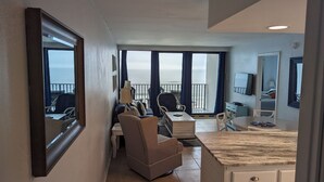 A spacious balcony with a view of the sea, a seating area with a sofa and chairs, and a small kitchen area with a table and cabinets. - Island Sunrise, sleeps 6, 2 bed / 2 bath, GULF VIEW-beach side (Gulf Shores)