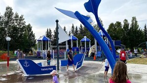 Et vandlegeområde med en bådformet vandinstallation og en blå markise.