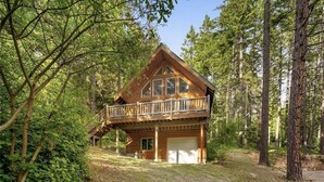 Eine Hütte mit Balkon, umgeben von Bäumen.
