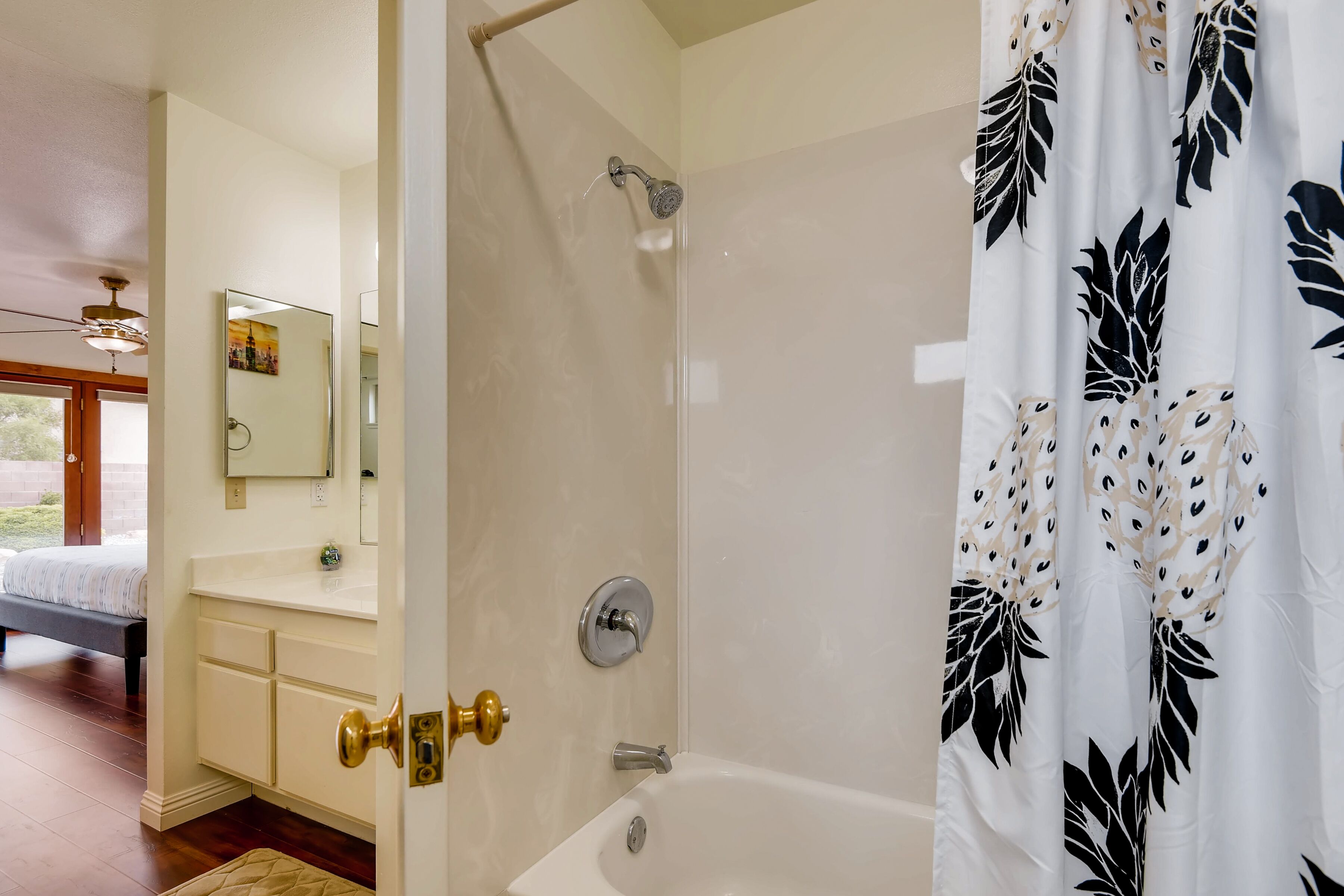 A bathroom with a shower, a sink, and a mirror.