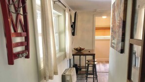 A hallway with wooden flooring, a table with chairs, and a radiator. - Ravens Hideaway Cottage on Main, King, KItchen, Living Rm, w/d &  Patio w/Grill (Westcliffe)