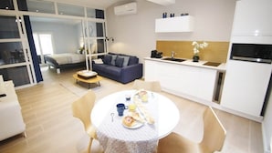 Un espacio habitable compacto con comedor, kitchenette y una cama con vistas.