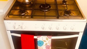 A white stove with four burners and a kettle on top. - "Your home in Miraflores" 4 pers (Lima)