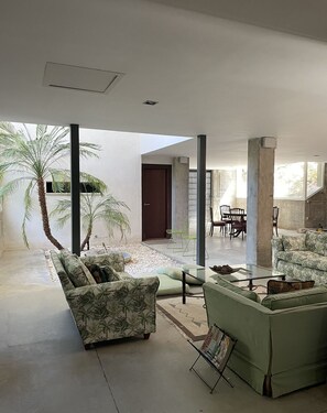 A spacious living area with a modern design, featuring a sofa set, a coffee table, and a dining area with chairs. - Single family Home (El Puerto de Sta María)