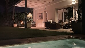 A modern outdoor patio with a pool, lounge chairs, and a dining area. - Single family Home (El Puerto de Sta María)