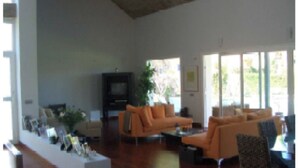 A spacious living room with a large orange sofa set, a flat-screen TV, and a coffee table. - Single family Home (El Puerto de Sta María)