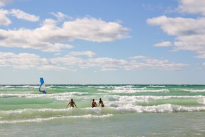 A beach scene with waves and a sailboat. - The Cottonwood Inn B&B (Empire)