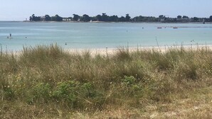 A beach with clear water, a sandy shore, and a line of trees in the background. - Île Tudy: House with 3 terraces  (ile tudy)