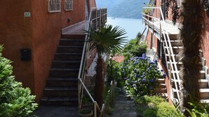 Un escalier étroit menant à un balcon d’où l’on peut admirer la mer.