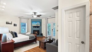 Une chambre d’hôtel équipée d’un lit, d’un bureau, d’une chaise, d’une cheminée et d’un téléviseur.
