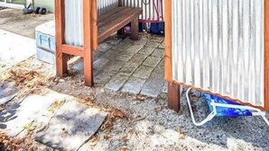Un espace extérieur abrité, doté d’une structure en pergola en bois et de murs en métal ondulé.