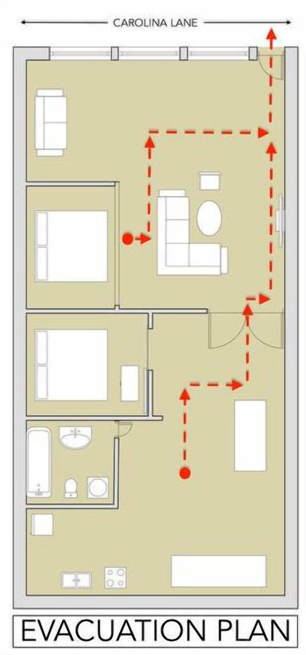 Piano di evacuazione per la planimetria di una camera d'albergo, con letto, bagno e angolo cottura.