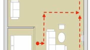 Piano di evacuazione per la planimetria di una camera d'albergo, con letto, bagno e angolo cottura.